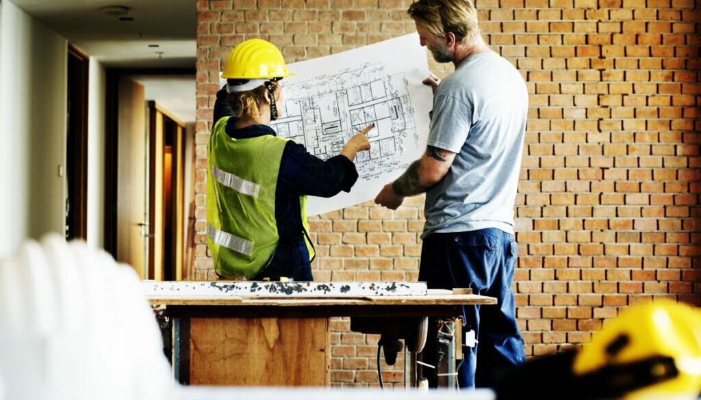 Optimized-construction-team-working-on-a-blueprint-PTWBMYW_1